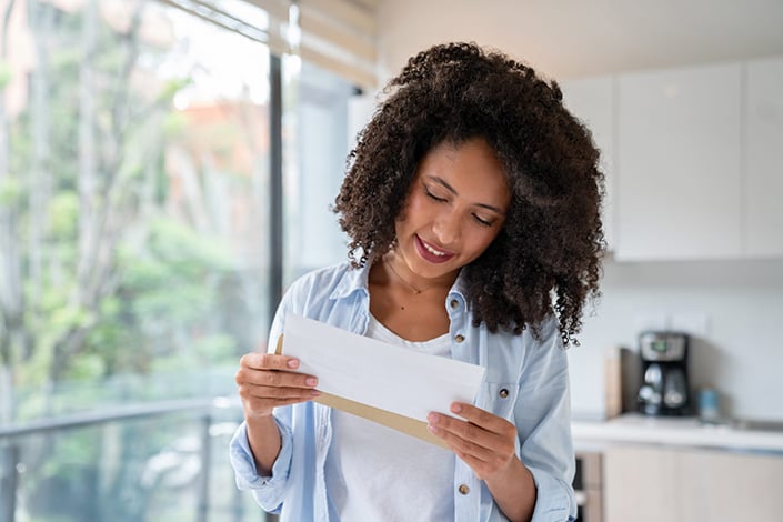 Woman opening a utilities letter.